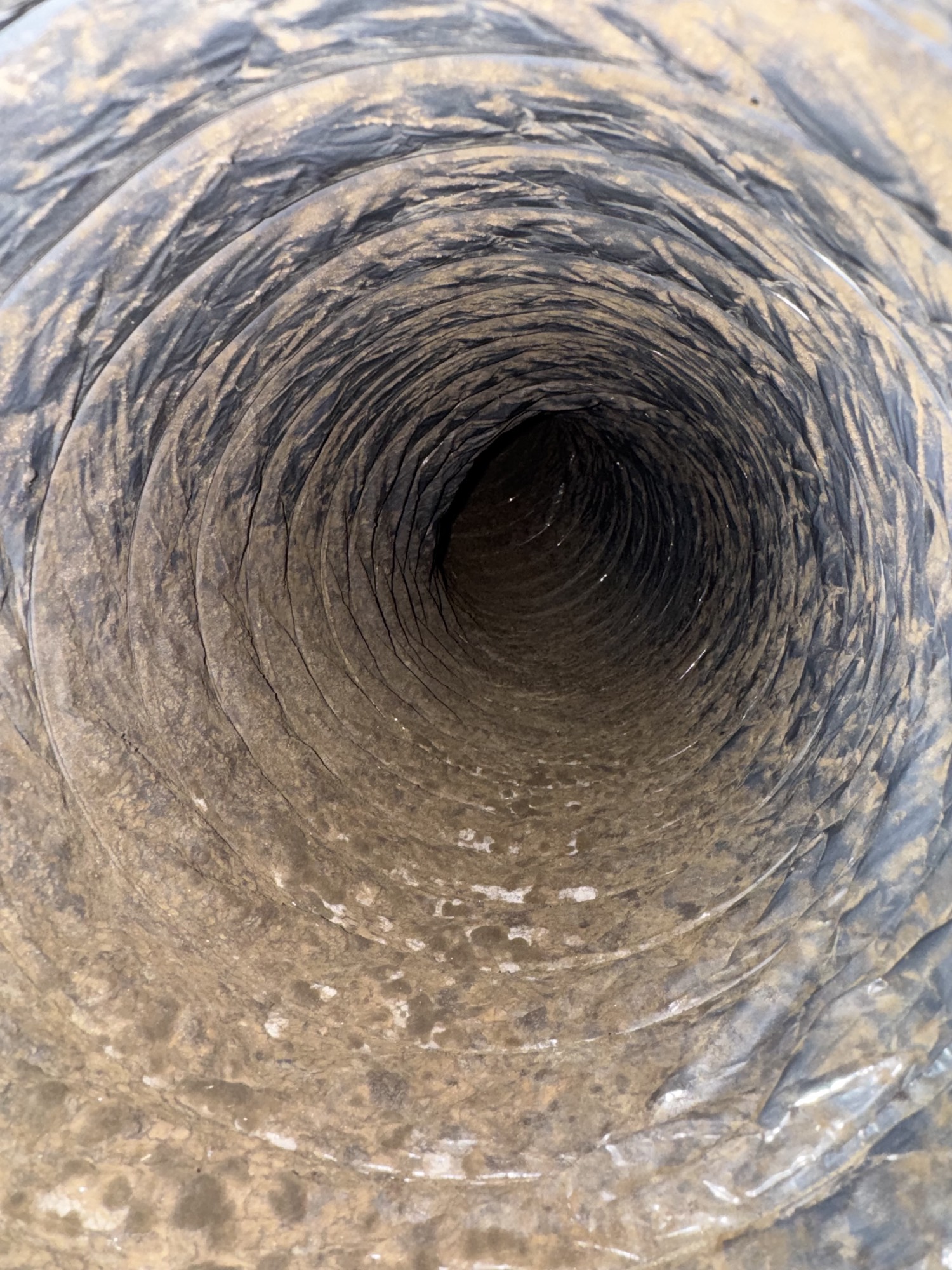 Dirty flex air duct lined with dust before cleaning in a Sugar Land home